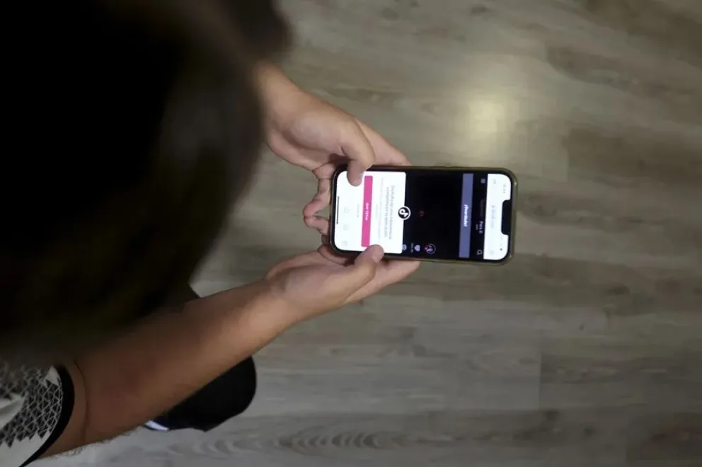 Una adolescente ve una red social en su teléfono móvil. Foto: EFE
