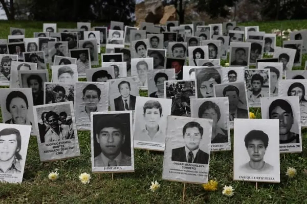 Fotografía que muestra carteles con imágenes de víctimas del conflicto interno de Perú, este viernes en el monumento 'El ojo que llora' en Lima (Perú). Foto EFE