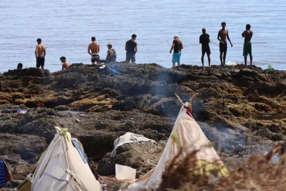 Migrantes en la playa de El Trampolín de Ceuta este sábado. Foto EFE