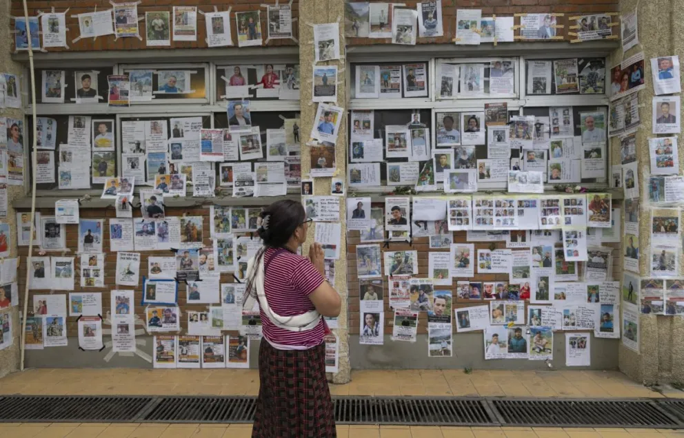Una persona este jueves frente a fotografías de personas desaparecidas tras las inundaciones repentinas en el Hospital Universitario de Enseñanza de Tribhuvan (TUTH) en Katmandú, Nepal. Foto: EFE