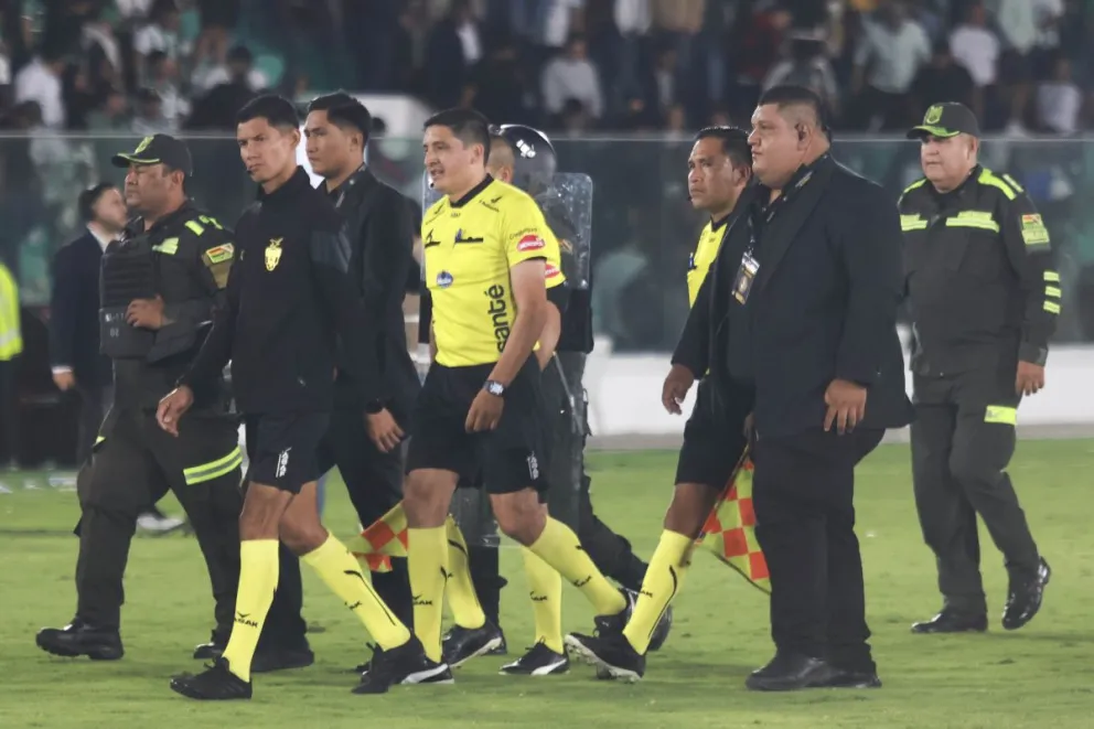 El juez Bladimir Rueda se retira de la cancha del Tahuichi con efectivos de seguridad. Foto: APG