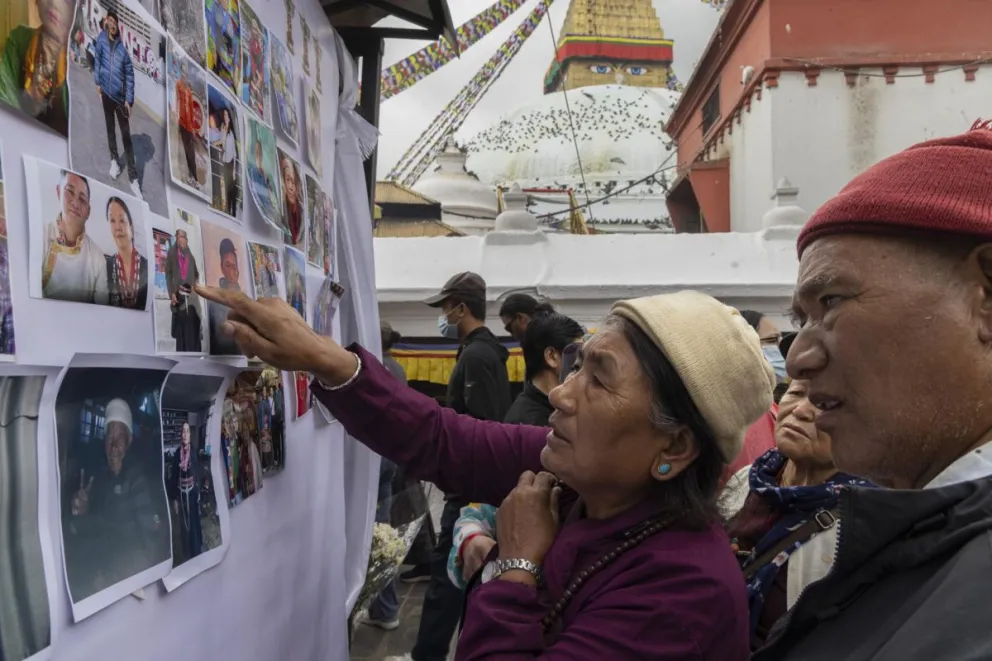 Familiares observan fotografías de las víctimas de las inundaciones repentinas en la frontera entre Nepal y el Tíbet, durante una ceremonia de oración y condolencias en Katmandú, Nepal. Foto: EFE