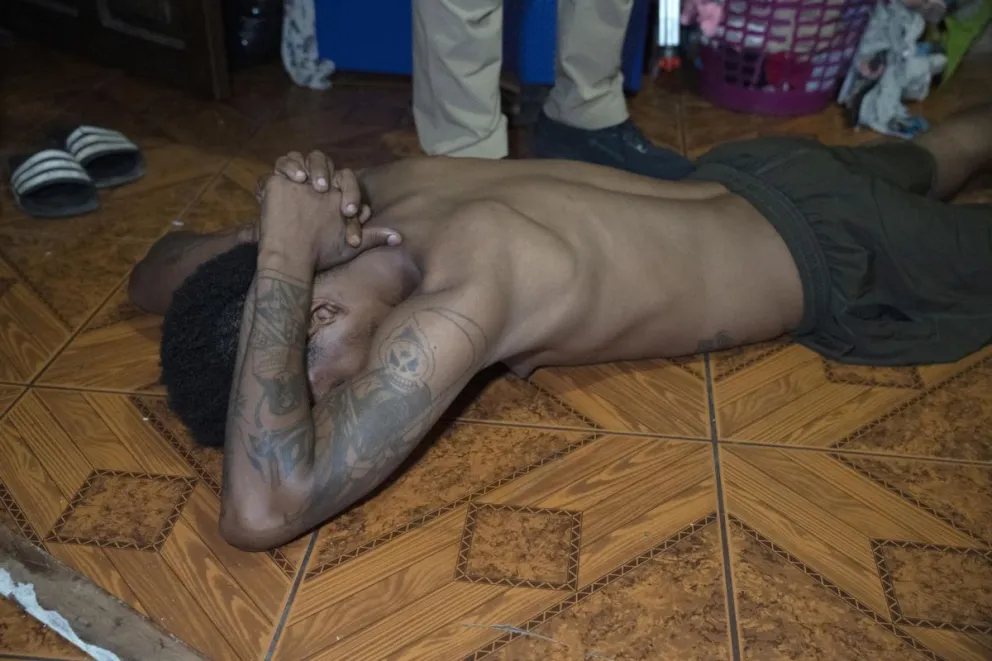 Una persona es custodiada durante un operativo realizado por la policía en la madrugada de este jueves en la población de Pasaje, provincia de El Oro (Ecuador). Foto: EFE