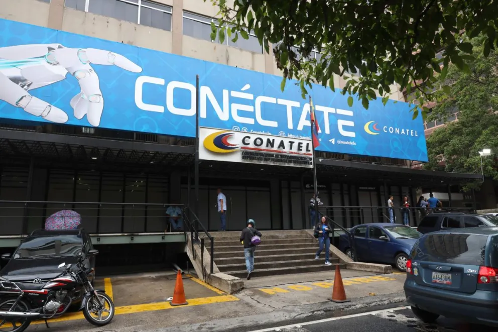 Un grupo de personas fue captado este 17 de septiembre al caminar frente a la sede principal de la Comisión Nacional de Telecomunicaciones (CONATEL), en Caracas (Venezuela). Foto: EFE