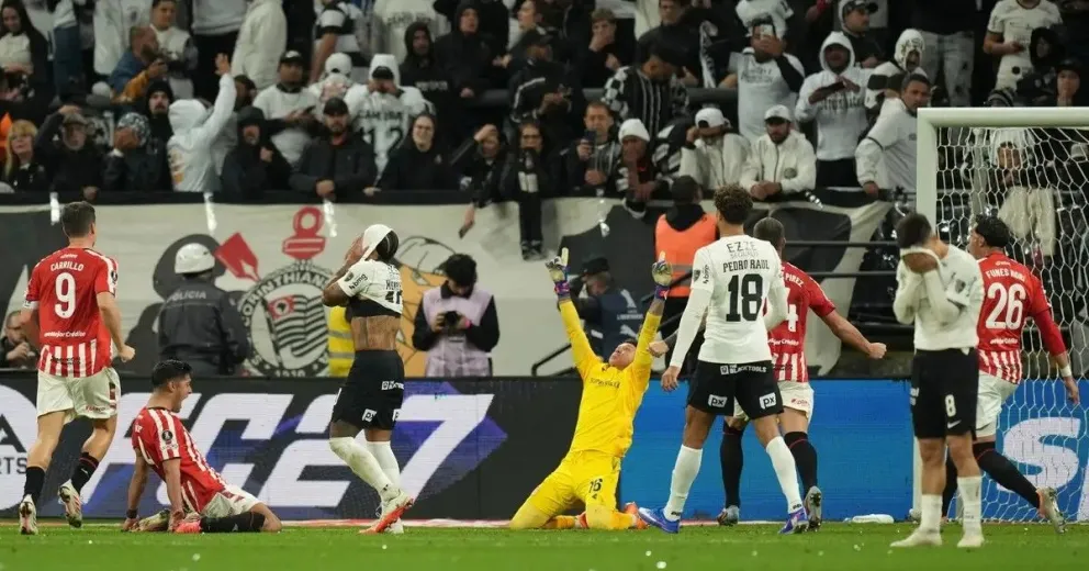 Memphis Depay, jugador del Corinthians, se tapa la cara con la camiseta tras fallar el penal; los de Estudiantes celebran la clasificación.