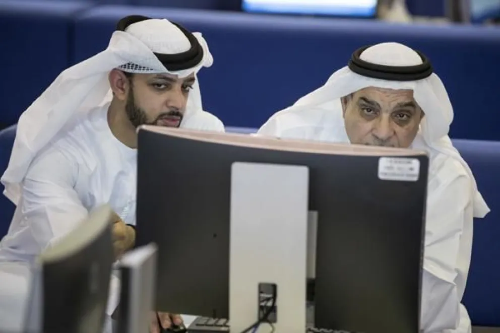 Operadores bursátiles observan la cotización de las acciones en una pantalla en el Mercado Financiero de Dubái, en Dubái (Emiratos Árabes Unidos). Foto: EFE