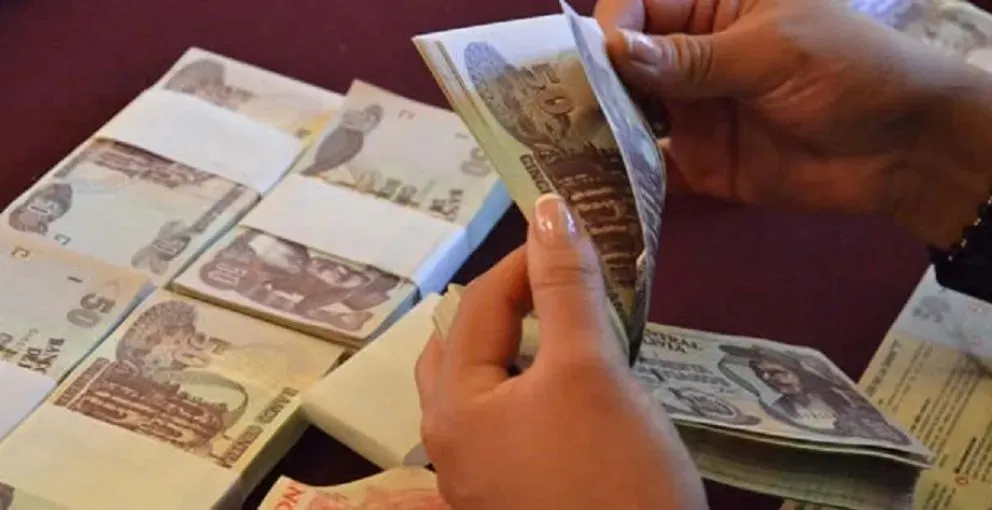 Una persona cuenta billetes de 50 bolivianos. Foto: ABI

