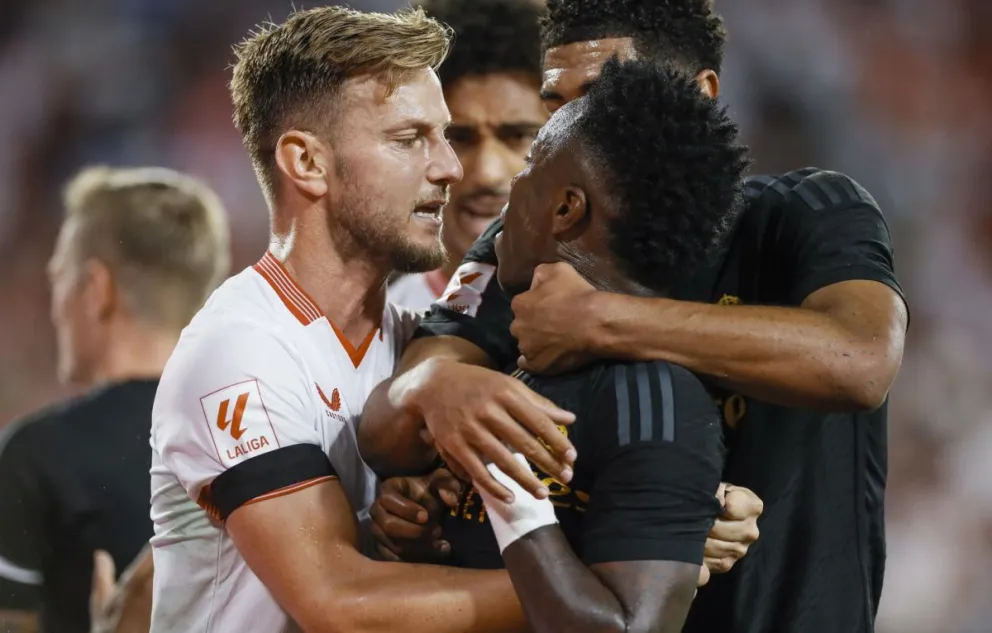 El brasileño Vinícius (centro) es sujetado por Ivan Rakitić del Sevilla y Jude Bellingham del Madrid durante el partido jugado el 21 de octubre de 2023. Foto: EFE.