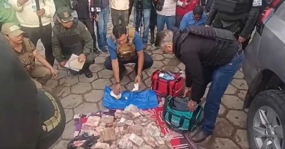 El dinero encontrado oculto en una ambulancia que salió del condominio donde vivía el fiscal General, Roger Mariaca. Foto: Captura de imagen