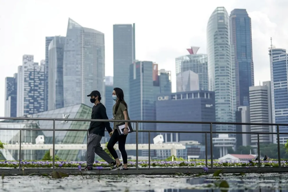 Una pareja camina en Singapur con el distrito financiero de fondo. Foto: EFE/