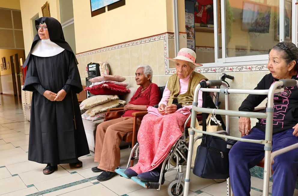 Una religiosa reacciona junto a adultos mayores en la casa asilo de las Hermanitas de los Ancianos Desamparados, en el Callao (Perú). Foto: EFE