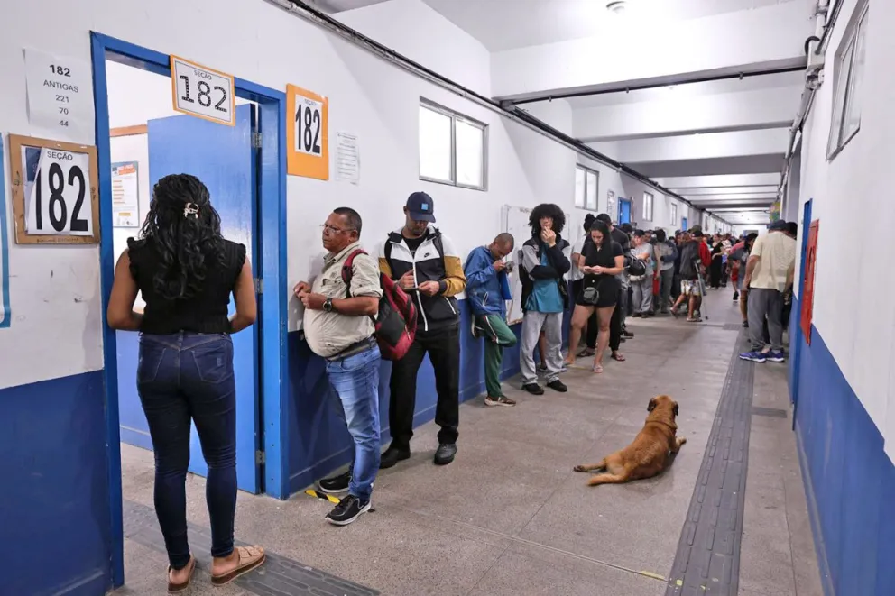 Votantes este domingo hacen fila en el colegio Ayrton Senna da Silva, cerca de la favela de Rocinha, en Río de Janeiro (Brasil). Foto: EFE