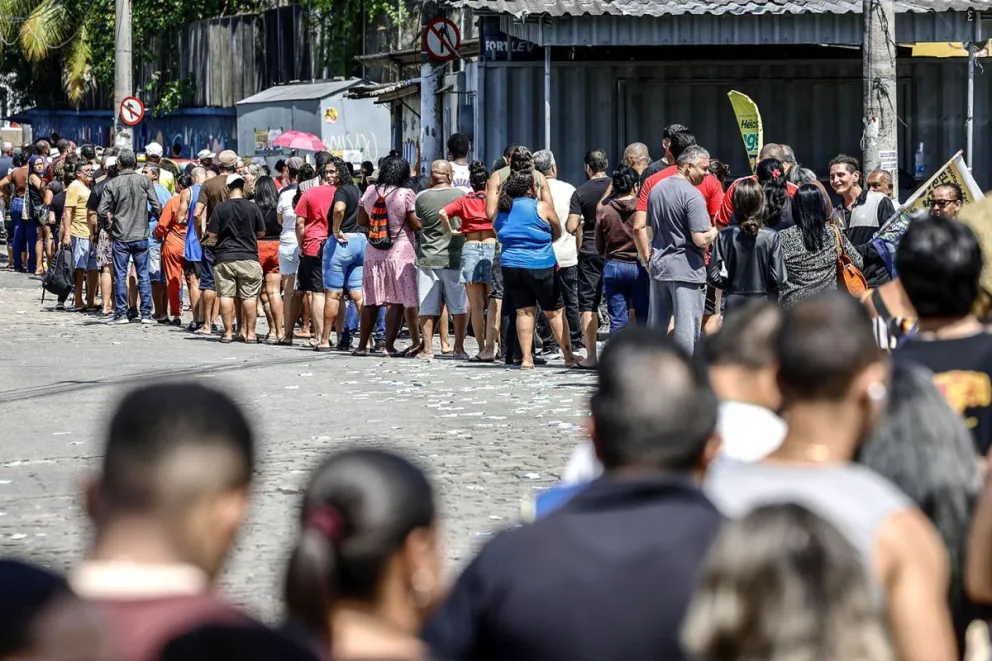 Personas hacen fila en un puesto de votación este domingo, en el barrio de Bonsucesso cerca al complejo de favelas de Maré, en Río de Janeiro (Brasil). Foto: EFE