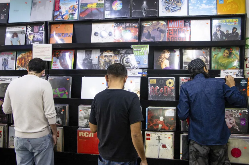 Jóvenes observan discos de vinilo este domingo, en Ciudad de México (México). EFE
