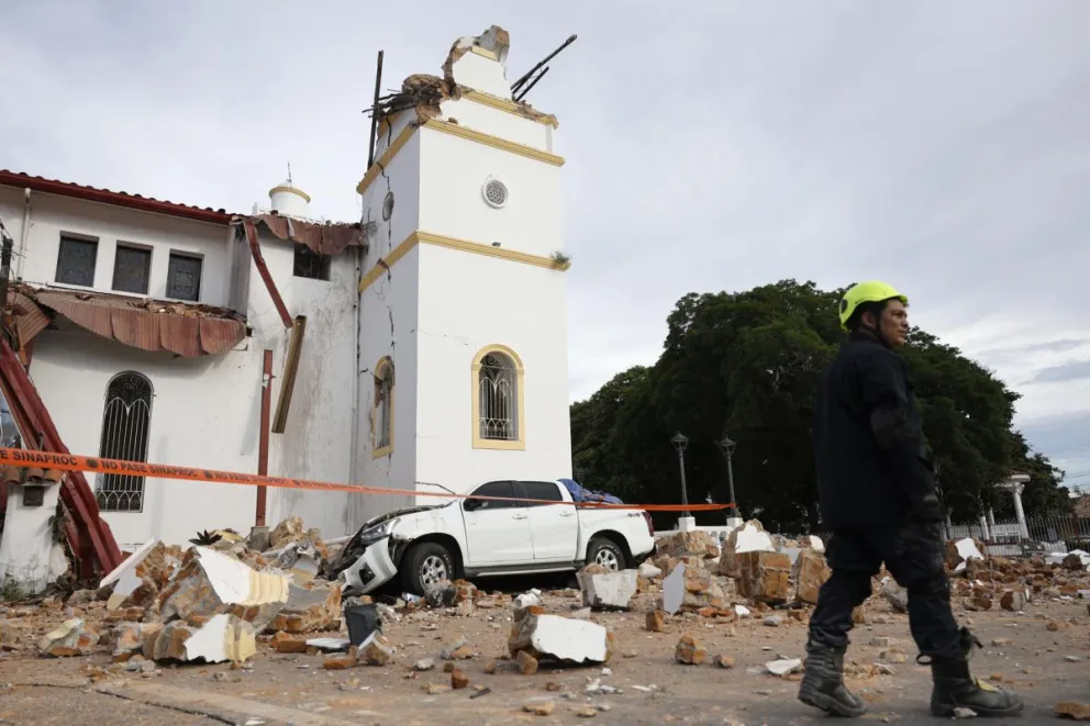 Socorrista camina frente a la Catedral San Juan Bautista, afectada por el terremoto de magnitud 7,7 que sacudió el sureste de Panamá y provocó daños en edificios y carreteras cercanas a Tonosí, epicentro del sismo, este viernes en Penonomé (Panamá). EFE