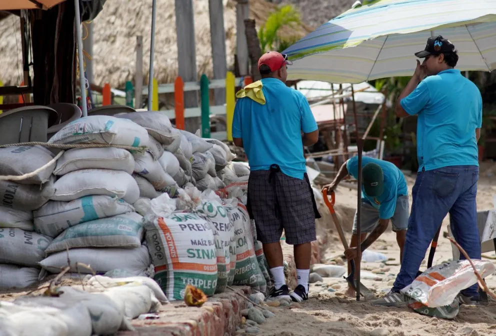 Trabajadores de negocios y restaurantes alistan barricadas ante el paso del huracán Simón ayer viernes, que alcanzó la categoría 2 en el Pacífico mexicano, con vientos sostenidos de 155 kilómetros por hora, en Puerto Vallarta (México). EFE/ Arturo Montero