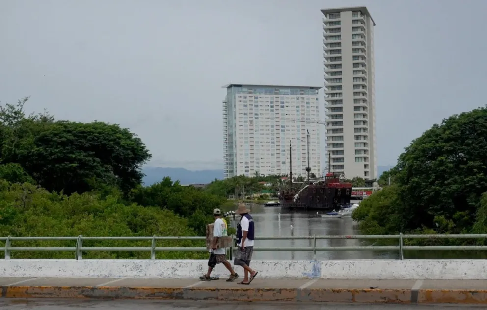 Personas caminan por un puente este domingo en Puerto Vallarta en Jalisco (México). EFE/Arturo Montero