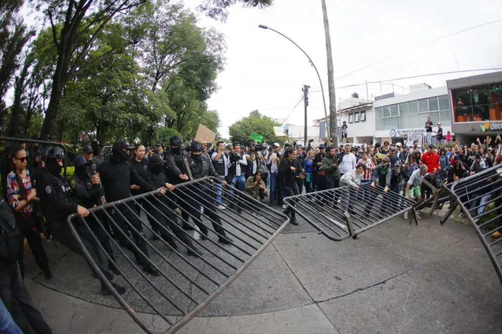 Personas se enfrentan con integrantes de la policía antimotines este domingo, en Guadalajara (México). Una manifestación por el agua contaminada en Guadalajara terminó con al menos nueve personas detenidas, cuatro con paradero desconocido. EFE