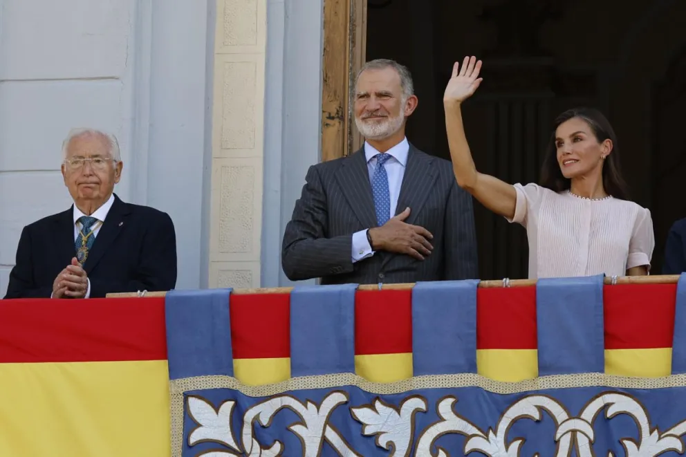 El rey Felipe VI (i) y la reina Letizia (d) saludan desde el balcón a los ciudadanos de Melilla. Foto: EFE