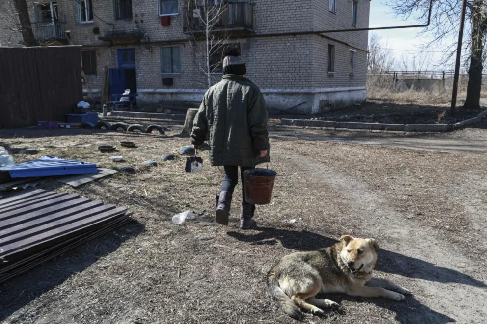 Una mujer transporta carbón para calentar su casa en el asentamiento de Spartak, cerca del frente de Donetsk en la parte de Ucrania controlada por Rusia, el 12 de marzo de 2024. Foto: EFE