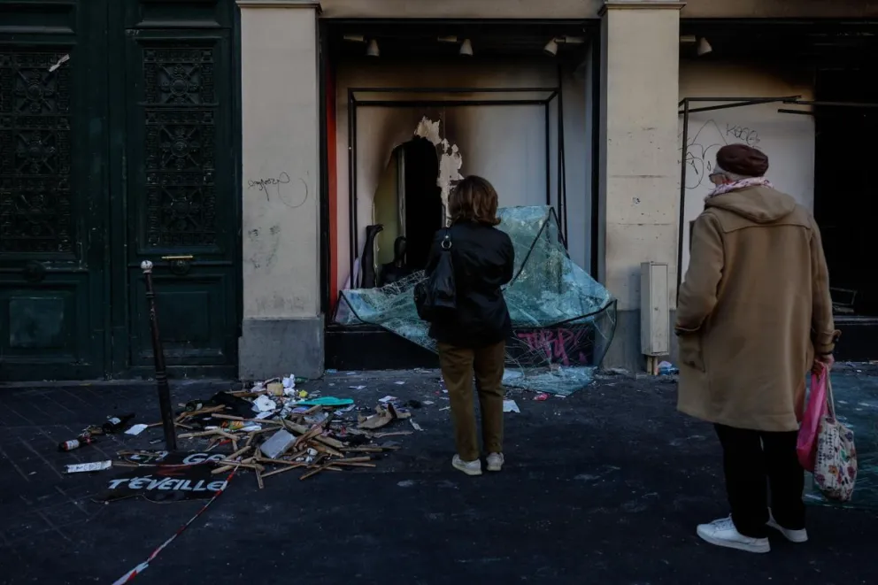 Unas personas observan los escombros que han quedado en la calle tras los enfrentamientos entre la policía antidisturbios y los manifestantes durante las protestas en París, Francia, el 18 de octubre de 2026. Foto: EFE/