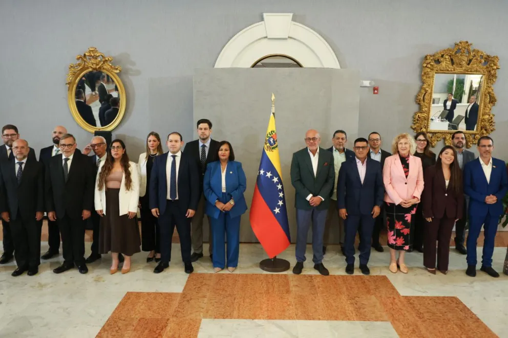 El presidente de la Asamblea Nacional de Venezuela, Jorge Rodríguez (c-d), la líder de la delegación opositora, Dinorah Figuera (c-i), y sus respectivos equipos posan, en Caracas (Venezuela). Foto: EFE