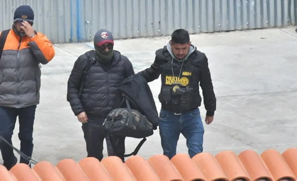 El oficial de la Policía Guillermo Ruiz es trasladado a la Felcc. Tiene la cabeza cubierta. Foto:DTV 
