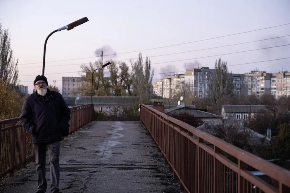 Un habitante de Jersón camina por un puente mientras el humo se eleva por un bombardeo ruso, en una imagen de archivo. Foto: EFE