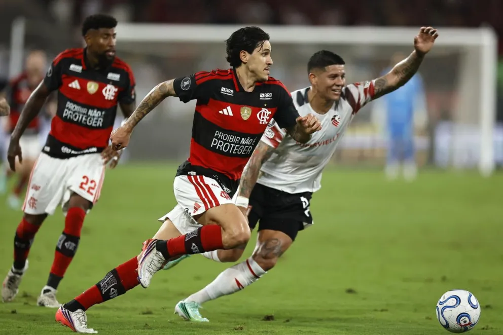 Pedro (centro), del Flamengo, disputa la pelota con Marcos Rojo de Estudiantes de la Plata. Foto: EFE