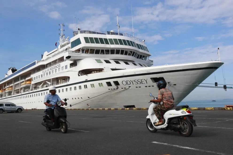 Trabajadores pasan en coche junto al crucero 'Odyssey', operado por Villa Vie Residences, atracado en el puerto de Sihanoukville en la provincia de Preah Sihanouk, Camboya, el 29 de octubre de 2026. Foto: EFE 