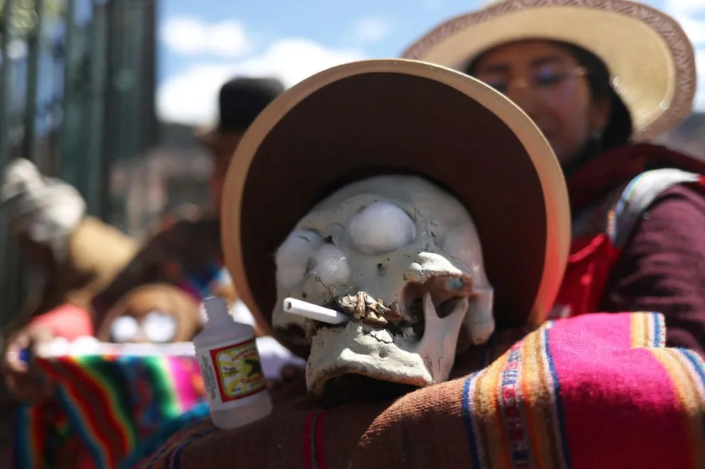 Una mujer sostiene una ñatita durante la fiesta de los difuntos, este viernes, en La Paz. Amautas aimaras desfilaron con cráneos humanos, que fueron colocados en un altar abierto al público para difundir las tradiciones dedicadas a los difuntos. EFE